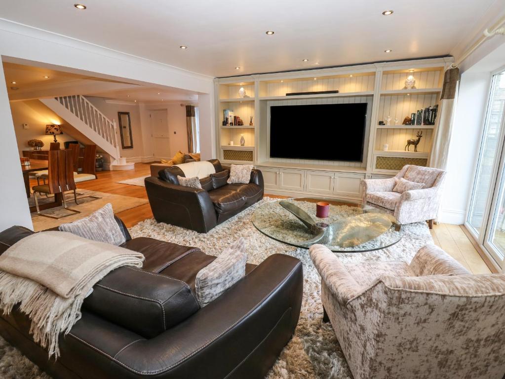 uma sala de estar com sofás e uma televisão de ecrã plano em Moor View em Glossop
