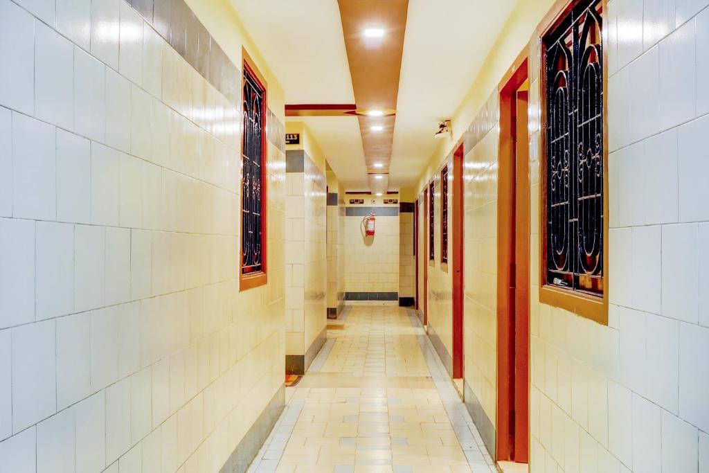 un corridoio vuoto in un edificio con pavimento piastrellato di OYO Sam Guest House a Chennai