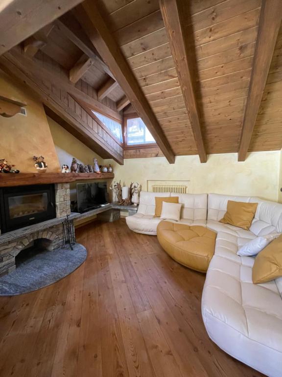 a living room with a white couch and a fireplace at Miramountains in La Thuile