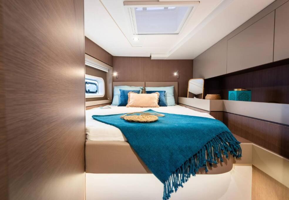 Un dormitorio con una cama con una manta azul. en Bateau privatisé Marin, en Sainte-Anne