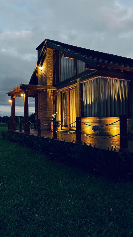 a wooden house with lights on the front of it at Mirador da Montanha in Praia Grande