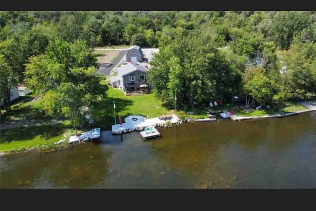 an aerial view of a house with a dock in the water at Riverfront Suites, Quinte, ON in Frankford