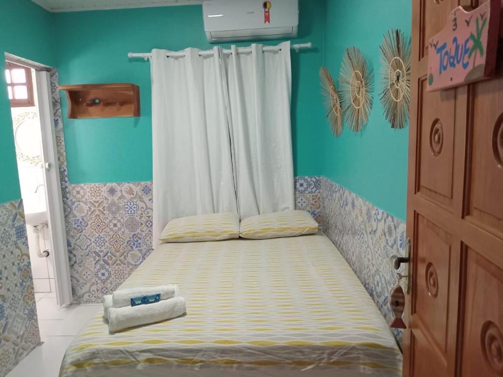 een klein bed in een kamer met blauwe muren bij Pousada Vila Milagres in São Miguel dos Milagres