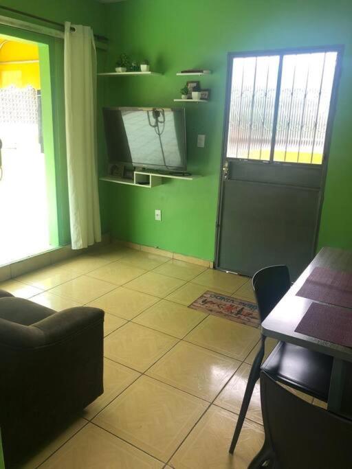 a room with green walls and a table and a door at Apartamento Natureza Verde Manauara in Manaus