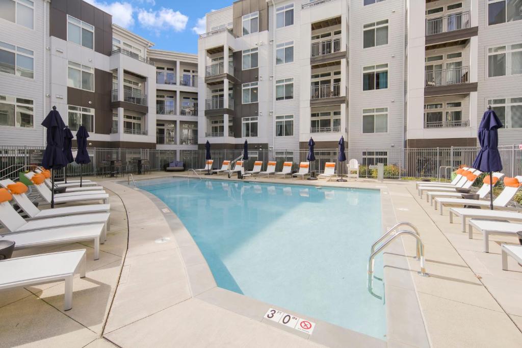a swimming pool with chairs and a building at Global Luxury Suites at Reston in Reston