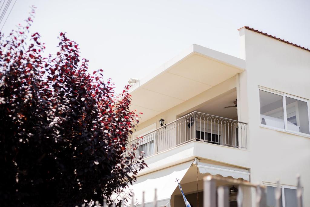 a white building with a balcony and a tree at Mareva's house in Vromerí