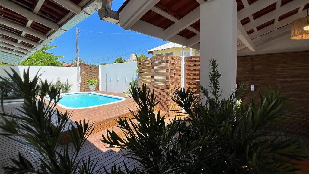un patio con piscina en el patio trasero en Casa 4 quartos piscina praia Mariscal Bombinhas SC, en Bombinhas