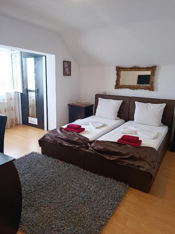 a bedroom with a bed with red pillows on it at Family Pension in Arad