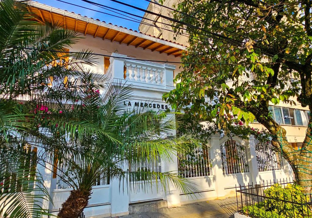 a white building with a tree in front of it at La Mercedes Boutique Hostal By MH in Cali