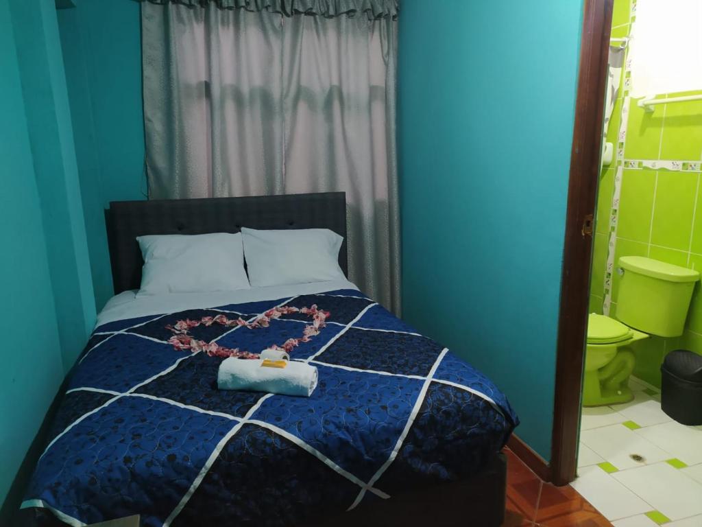 a blue bedroom with a bed with a necklace on it at HOSPEDAJE EL ARCO in Ayacucho