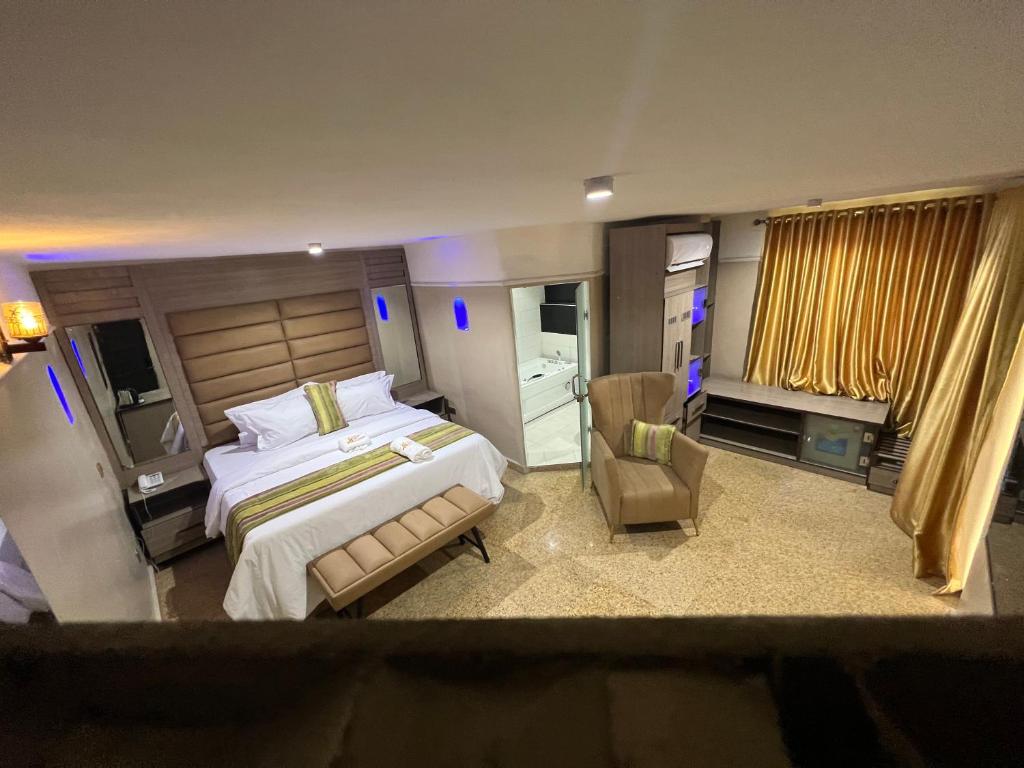 a large bedroom with a large bed and a chair at Ikeja Airport View in Lagos