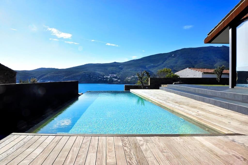uma piscina com um deque de madeira e água em Lujo y vistas espectaculares. em Cadaqués