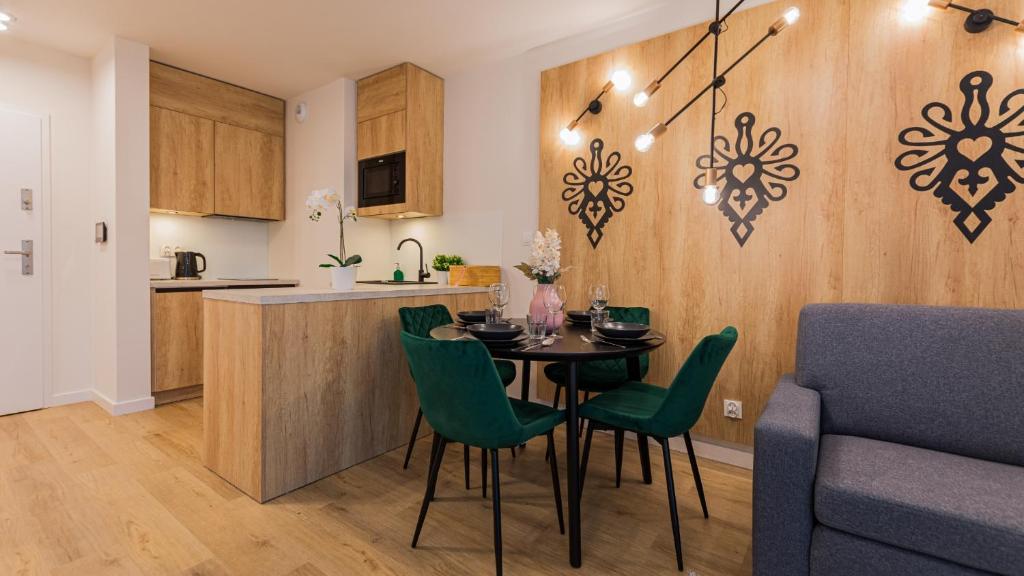 uma cozinha e sala de jantar com mesa e cadeiras em VacationClub - Apartamenty Zakopiańskie Apartament 412 em Zakopane