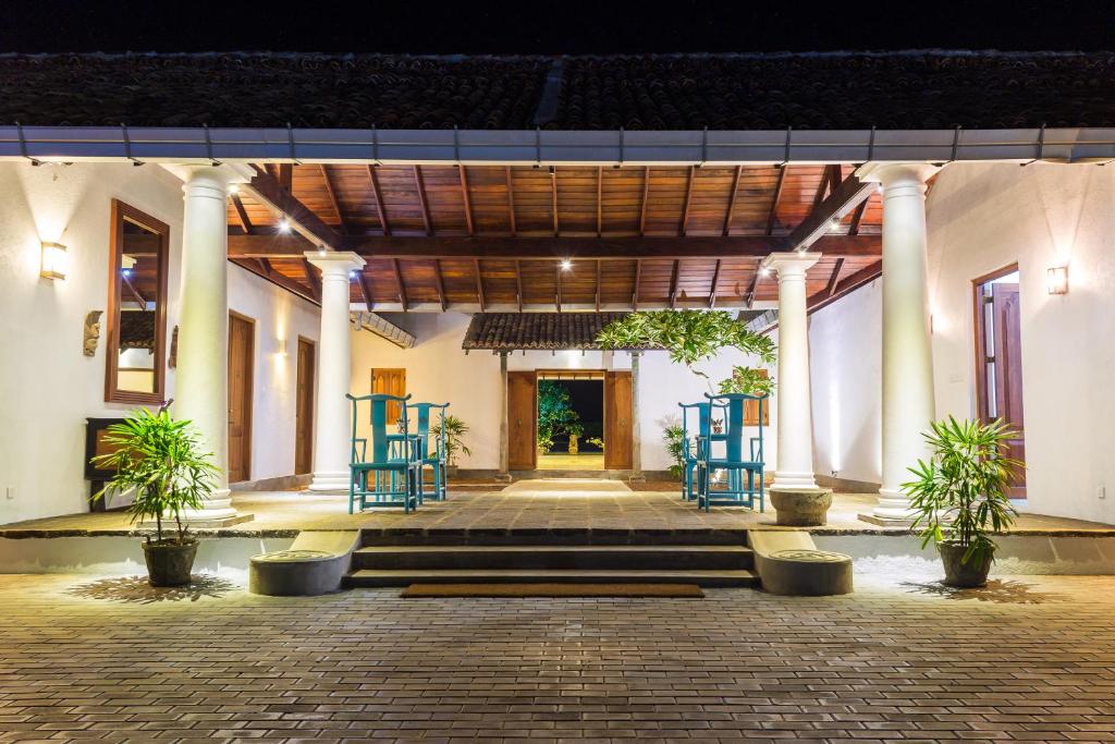 a building with pillars and chairs in a courtyard at Amaloh Boutique Resort in Matara