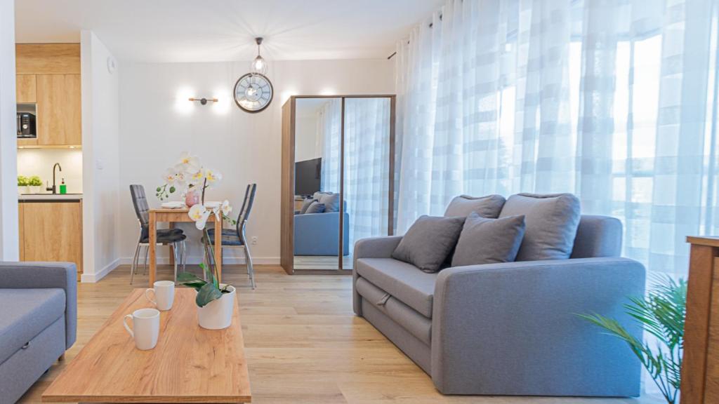 uma sala de estar com um sofá azul e uma mesa em VacationClub - Apartamenty Zakopiańskie, Apartament 328 em Zakopane