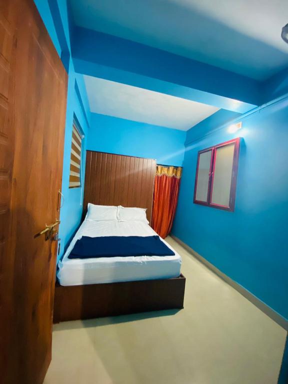 1 dormitorio con 1 cama con paredes azules y puerta en VEE CEE TOWER FURNISHED APPARTMENT, en Sultan Bathery