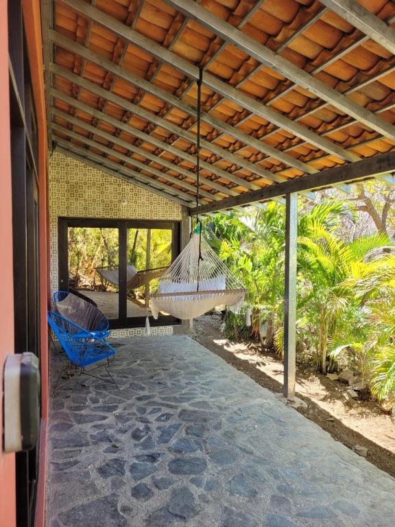 a porch with a hammock on a house at Casa del Arte - Playa Maderas in Playa Maderas