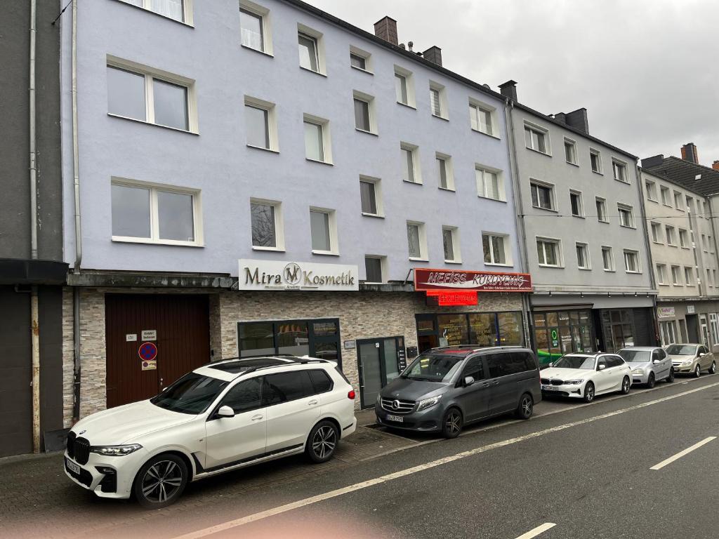 ein weißes Auto, das vor einem Gebäude parkt in der Unterkunft Ferienwohnung in Bochum