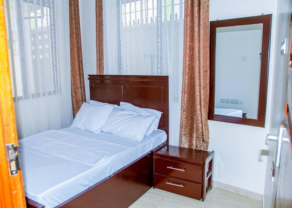 a small bedroom with a bed and a mirror at Happiness at the center of the town morogoro in Morogoro