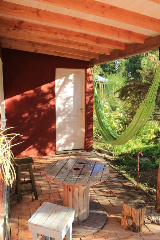 a patio with a door and a table and a bench at la colorida 2 in Lago Puelo