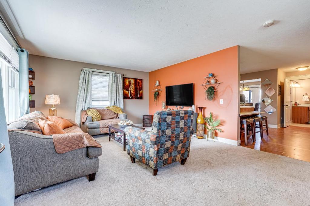 a living room with two chairs and a tv at Charming Kalamazoo Home with Yard 1 Mi to Downtown! in Kalamazoo