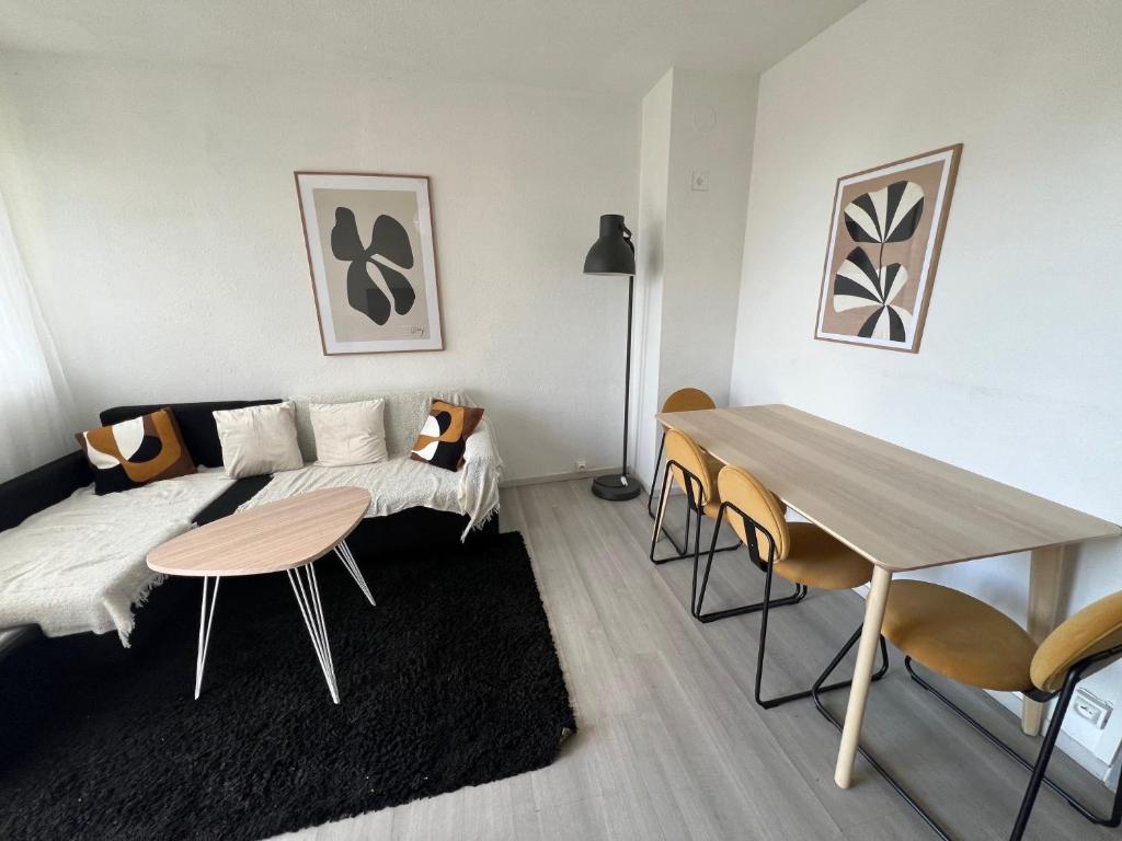 um quarto com uma cama, uma mesa e cadeiras em COSY F3 PROCHE CENTRE em Belfort