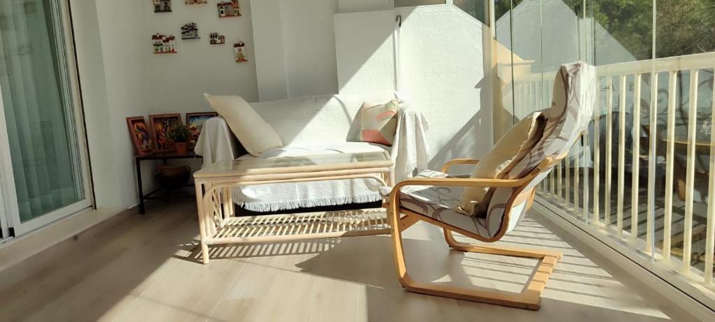 a rocking chair sitting on a porch with a balcony at BEACH FOREST PARADISE in Cabopino