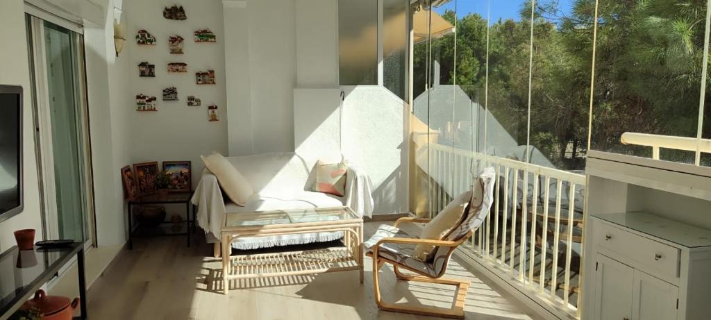 a balcony with two chairs and a large window at BEACH FOREST PARADISE in Cabopino