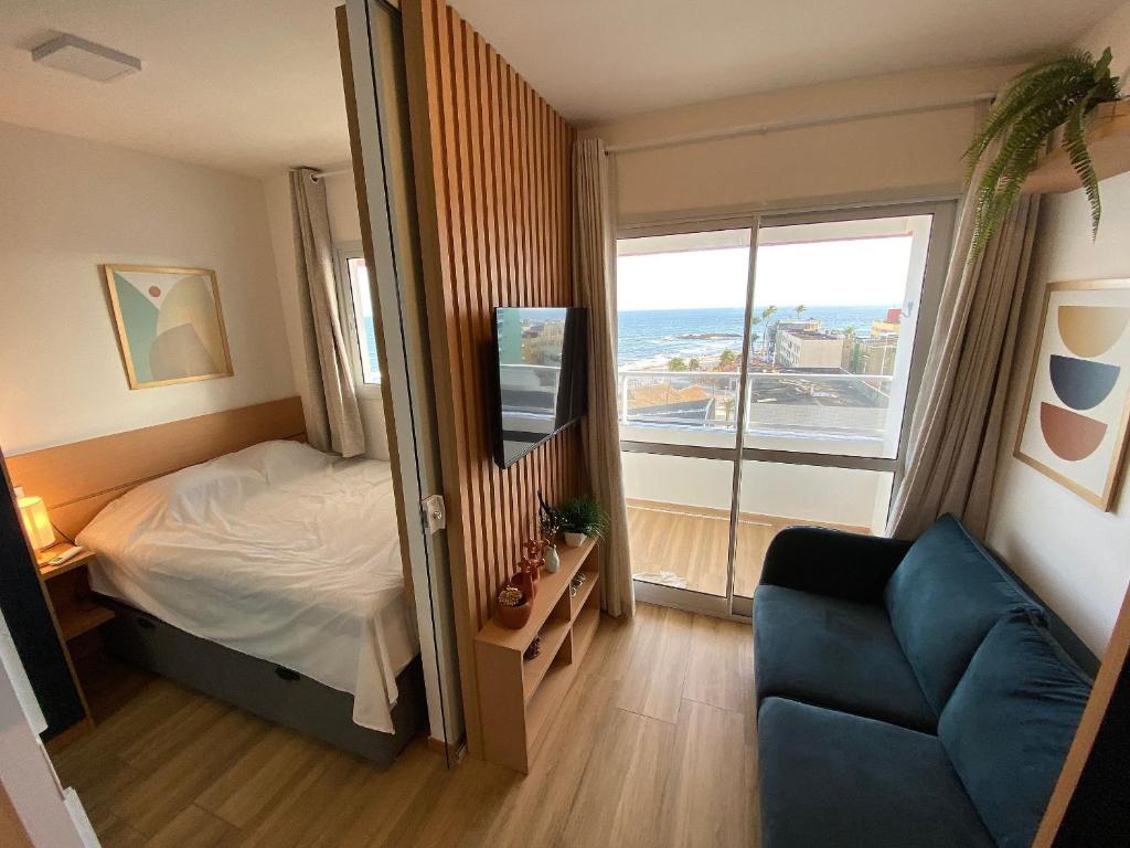 1 dormitorio con cama, sofá y ventana en Apartamento Luxuoso com Vista Mar no Smart Pituba, en Salvador