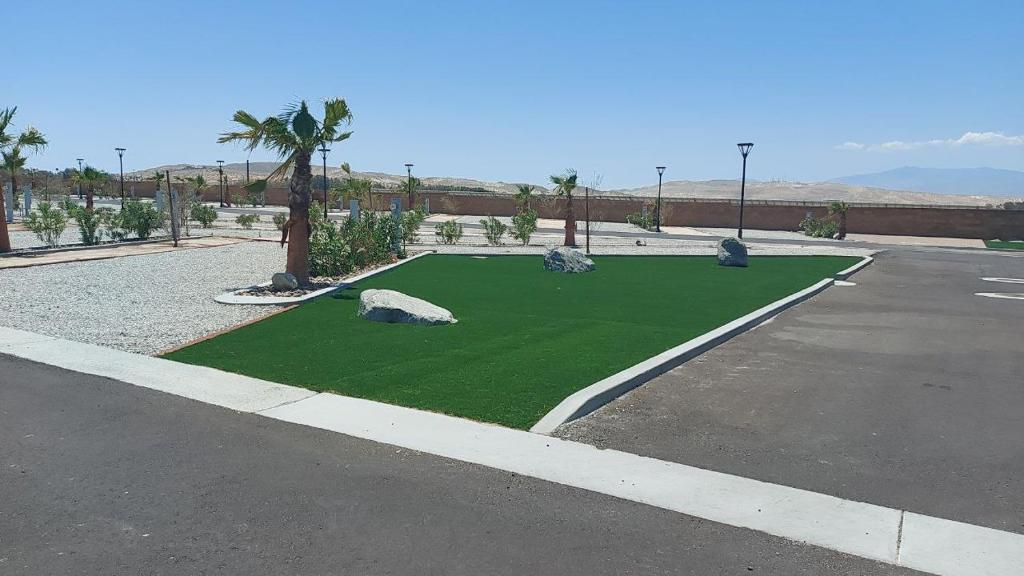 un pequeño campo de césped artificial en un estacionamiento en RV41-LOT ONLY- Paradise RV park, en Desert Hot Springs