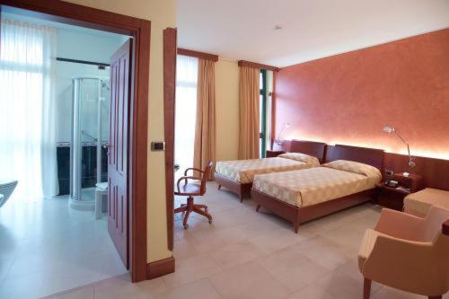カルマニョーラにあるAlbergo Ristorante San Marcoのベッドルーム1室(ベッド2台付)、スライド式ガラスドアが備わります。