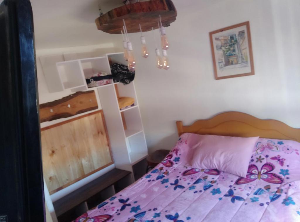 1 dormitorio con 1 cama con edredón morado en Departamento valpo en Valparaíso