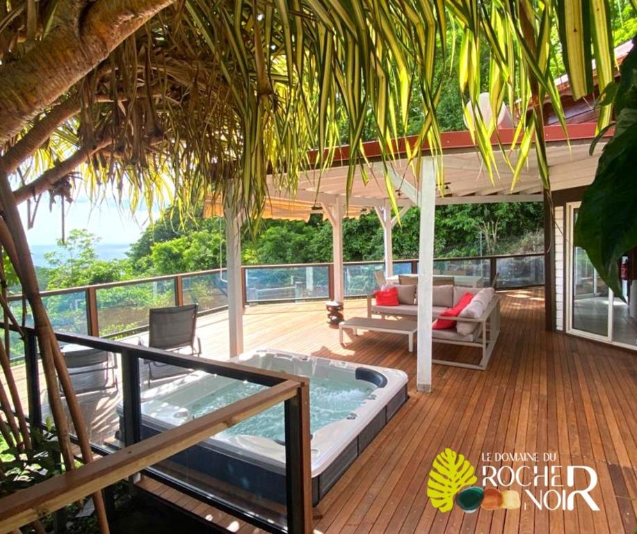 a patio with a hot tub on a deck at Le Domaine du Rocher Noir in Pointe-Noire