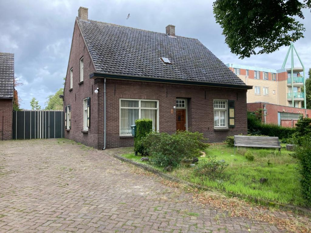 a brick house with a bench in front of it at Het werkhuis in Uden