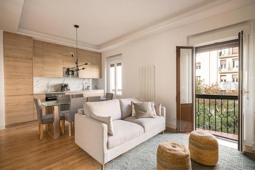 uma sala de estar com um sofá e uma mesa em NEW, Modern and Luxurious, 3BR Apt em Madri
