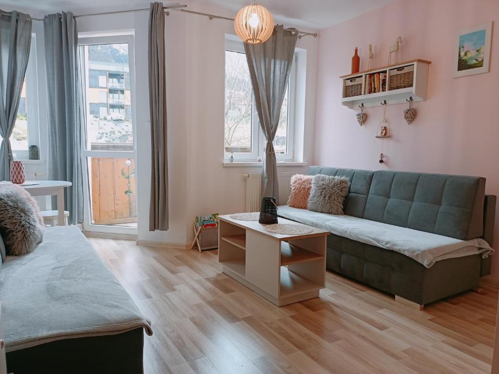 ein Wohnzimmer mit einem Sofa und einem Tisch in der Unterkunft Studio TERJANO in Karpacz