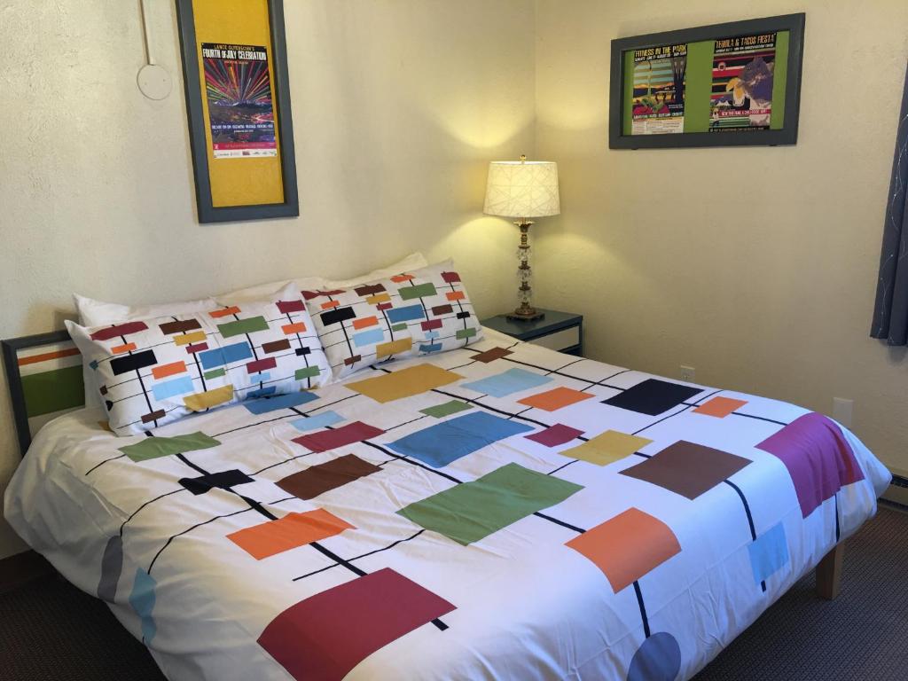 a bed with a colorful quilt on it in a room at The Viking Lodge - Downtown Winter Park Colorado in Winter Park