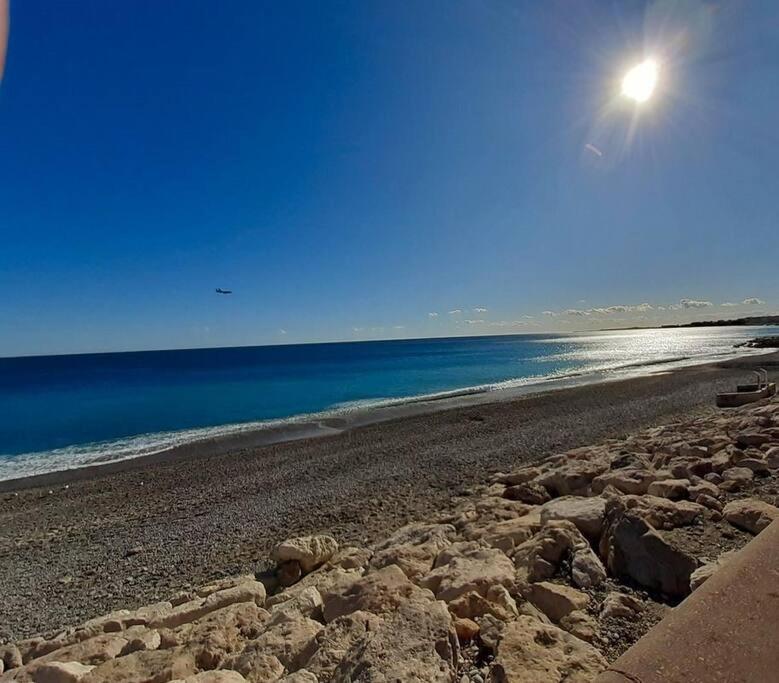 - une plage avec des rochers et le soleil dans le ciel dans l'établissement Studio - Magnan NICE, à Nice