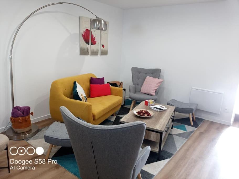 uma sala de estar com um sofá amarelo e cadeiras em Ty-Reviens em Lanrivoaré