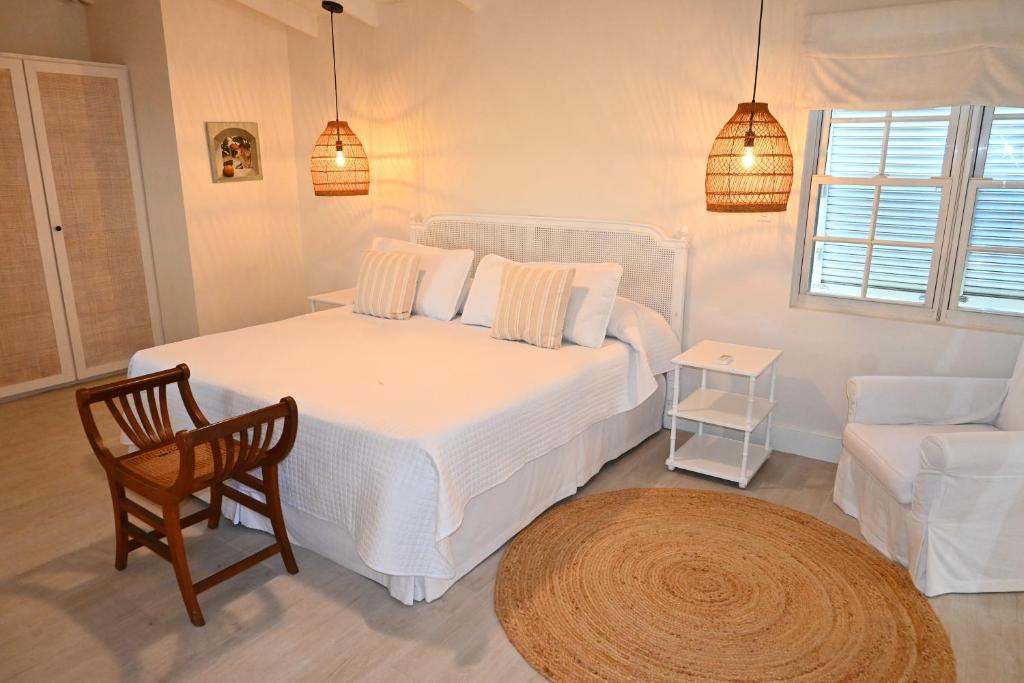 1 dormitorio con 1 cama blanca, 1 silla y 1 sofá en Little Good Harbour, en Saint Peter