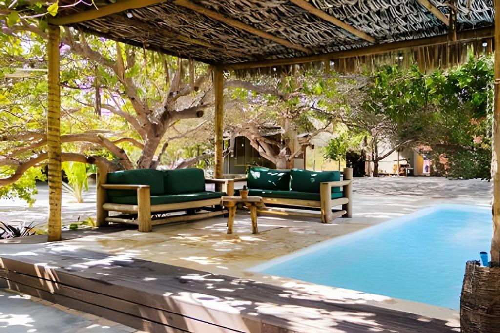 a patio with two chairs and a table next to a pool at Casa agradável no sossego de BG: até 18 pessoas in Barra Grande