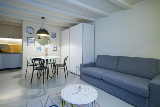 een woonkamer met een bank en tafels en een keuken bij Studio Suite Mirakul in Komiža