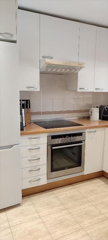 a kitchen with white cabinets and a stove top oven at BEACH FOREST PARADISE in Cabopino