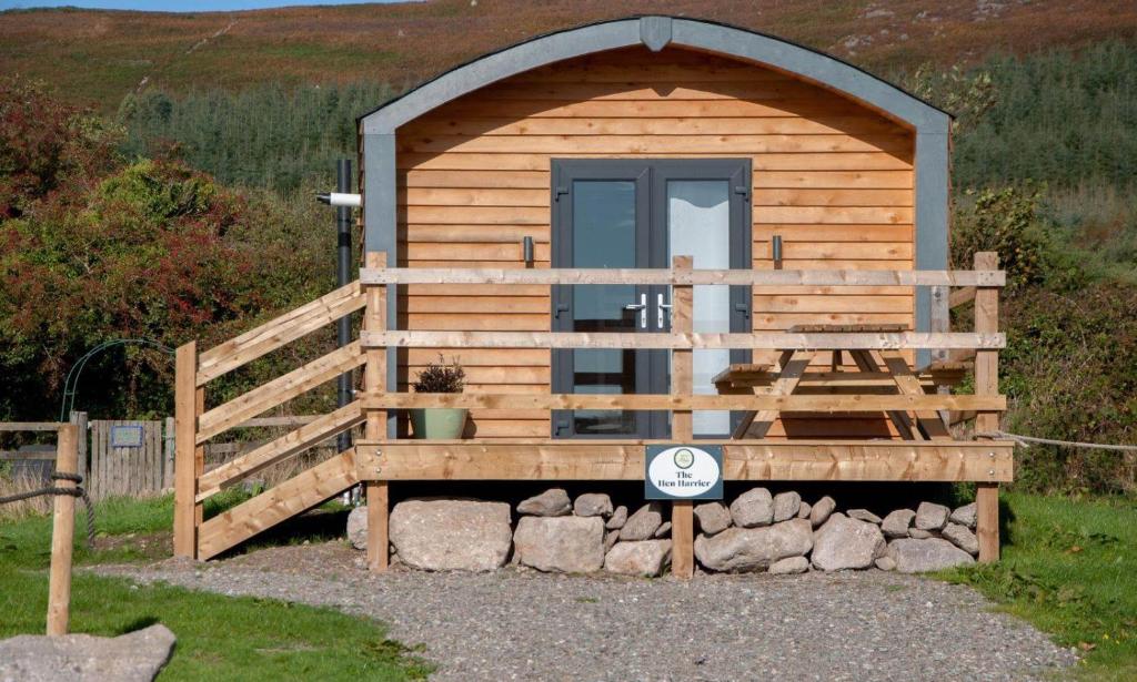 eine Holzhütte mit einem Tor und einer Tür in der Unterkunft The Hen Harrier - 4 Person Luxury Glamping Cabin in Dungarvan