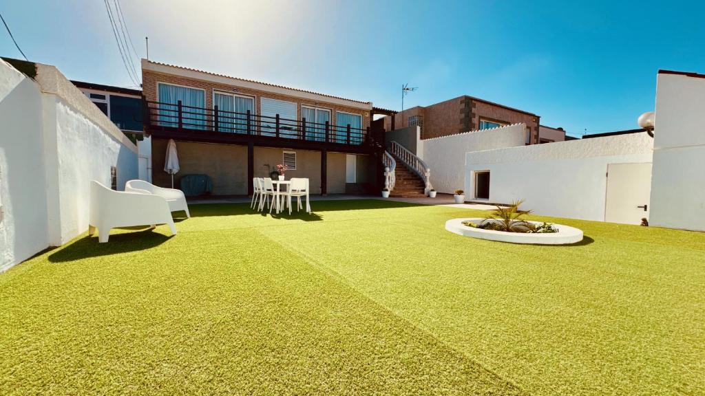 a backyard with a lawn with a table and chairs at Click&Guest - Blue Marine in Playa del Hombre in Telde