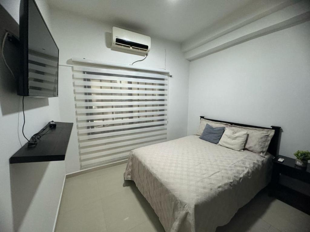 ein kleines Schlafzimmer mit einem Bett und einem TV in der Unterkunft Casa En Leticia in Leticia