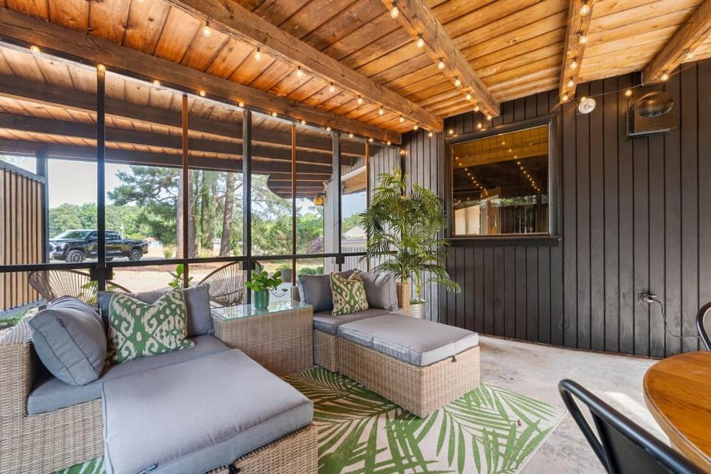 un porche cubierto con sofá y mesa en That 70's Hive - Retro Retreat w Beaches Pool + Tennis, en Montross