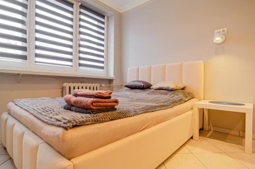 sypialnia z łóżkiem z ręcznikami w obiekcie OMMPBooking w mieście Częstochowa