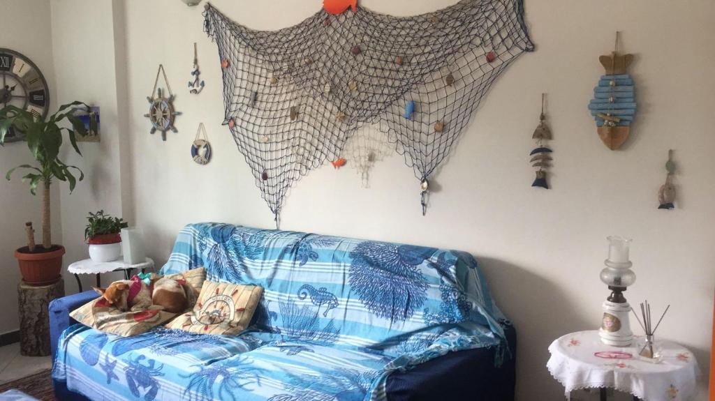 een blauwe bank in een woonkamer met een muur met decoraties bij A due passi dal mare in Loano