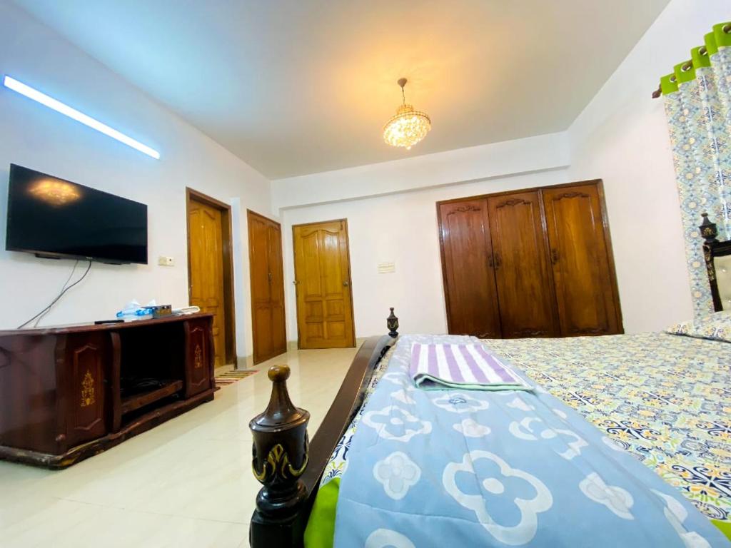 1 dormitorio con 1 cama y TV de pantalla plana en Gulshan 1-Cozy Private Attached bath Room Ac Tv & Netflix, en Dhaka